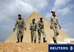 Varios soldados egipcios pasan junto a las pirámides de Giza, en El Cairo, el 9 de febrero de 2011.
