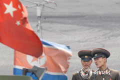 Corea del Norte desarrollará plan de ataque a Guam para mediados de agosto Dos soldados norcoreanos al lado de las banderas de China y de Corea del Norte en un barco en el río fronterizo Yalu el 10 de junio de 2013