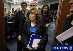la vicepresidenta del Gobierno, Soraya Sáenz de Santamaría (C), abandona la rueda de prensa tras un Consejo de Ministros seguida por el ministro de Economía, Luis de Guindos, en el Palacio de la Moncloa en Madrid el 30 de diciembre de 2011