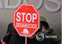 La gente sostiene pancartas durante una protesta contra los desalojos en frente de un tribunal en Burgos 09 de febrero 2012