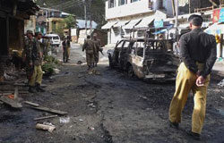 Un suicida mata a 41 personas en Pakistán con una bomba fuerzas de seguridad aseguran el lugar de la explosión en el distrito Shangla, Pakistán, el 12 de octubre de 2009. mientras los talibanes se atribuían.