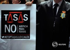 Un abogado con un cartel contra las tasas judiciales en Oviedo el 20 de noviembre de 2013 Un abogado con un cartel contra las tasas judiciales en Oviedo el 20 de noviembre de 2013