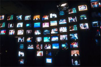 Un montón de pantallas de televisión sobre una pared.
