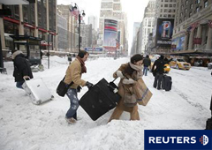 Varias personas llevan su equipaje por una montaña de nieve en la 7º Avenida en Nueva York el 27 de diciembre de 2010