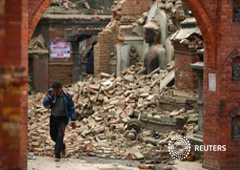 Un hombre llora mientras camina junto a una estatua de Buda en una calle derruida, en una fotografía tomada en Bhaktapur el 26 de abril de 2015