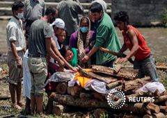 Una mujer llora mientras su el cuerpo de su padre es preparado para la cremación, en Katmandú, el 27 de abril de 2015