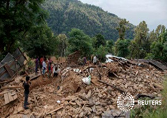Unos habitantes cerca de una casa donde fallecieron tres personas por el terremoto en la población de Jharibar Village, en Gorkha, Nepal, el 28 de abril de 2015