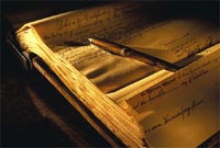 Una pluma escribiendo sobre un papel la palabra Testament