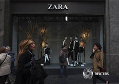 Un grupo de personas pasa junto a una de las tiendas de Zara en Madrid