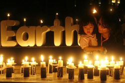 una mujer lleva en brazos a su hija mientras miran velas encendidas con motivo de la Hora del Planeta en Yakarta el 27 de marzo de 2010.