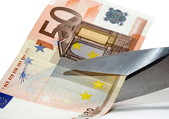 Una tijera cortando un billete de 50 euros