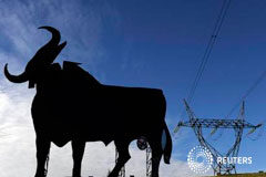 La asociación de consumidores teme un alza de las tarifas de la luz Una torre de la luz junto a un cartel de un toro en El Berrón, cerca de Oviedo, el 26 de diciembre de 2013