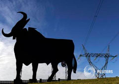 Una torre de la luz junto a un cartel de un toro en El Berrón, cerca de Oviedo, el 26 de diciembre de 2013
