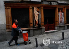 Un trabajador postal pasa junto a un bar en el centro de Madrid, el 3 de enero de 2018