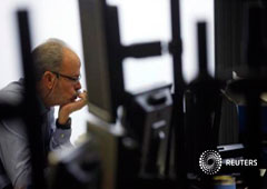 Un trader mira su pantalla en la sala de tesoreria de Inversis durante la subasta de bonos en Madrid el 10 de enero de 2013