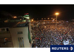 La bandera del reino de Libia ondea mientras una multitud se concentra en Bengasi, el 22 de agosto de 2011.