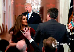 Una miembro del personal de la Casa Blanca intenta tomar el micrófono en manos del periodista de CNN Jim Acosta en medio de una conferencia de prensa del presidente Donald Trump en la Casa Blanca, en Washington, EEUU, Noviembre 7, 2018.