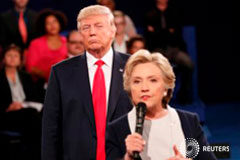 Clinton supera a Trump por 8 puntos tras escándalo por grabación – sondeo Trump escucha mientras Clinton responde una pregunta de la audiencia durante su debate en la Universidad de Washington en St. Louis, Missouri, el 9 de octubre de 2016