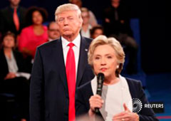 Trump escucha mientras Clinton responde una pregunta de la audiencia durante su debate en la Universidad de Washington en St. Louis, Missouri, el 9 de octubre de 2016