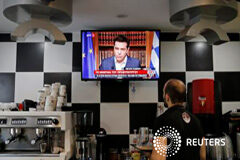 Primer ministro griego Tsipras lanza ofensiva contra el rescate Un camarero en una cafetería mira una pantalla en la que Tsipras habla a los ciudadanos, en Atenas, Grecia, el 1 de julio de 2015