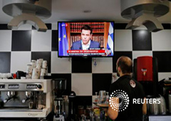 Un camarero en una cafetería mira una pantalla en la que Tsipras habla a los ciudadanos, en Atenas, Grecia, el 1 de julio de 2015