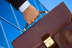 La Dirección General de Tributos confirma que los abogados del Turno de Oficio no están sujetos al IVA Una mano llevando un maletín.