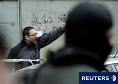 Txelui Moreno levanta el puño mientras guardias civiles detienen a su hijo Iker, durante una operación en Burlada el 18 de enero de 2011.