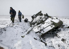 Los miembros del autoproclamado ejército de la República Popular de Donestsk recogen piezas de un tanque ucraniano destrozado cerca de la ciudad de Vuhlehirsk, el 16 de febrero de 2015