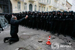 Los ucranianos protestan en masa contra el desaire de Yanukovich a Europa Un hombre se arrodilla ante la policía antidisturbios durante la manifestación de partidarios de la integración con la UE, en Kiev, el 1 de diciembre de 2013