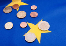 ¿Qué es y cómo nos afecta la nueva Directiva PSD2? Monedas de euro sobre bandera de la UE