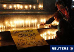 Dos personsa colocan un vela durante la vigilia tras la muerte del ex presidente Néstor Kirchner frente al Palacio Presidencial en Buenos Aires, el 27 de octubre de 2010.