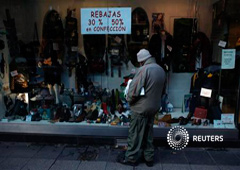 Un hombre mira un escaparte en una zona comercial en Madrid, el 21 de enero de 2013
