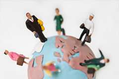 Los derechos de los viajeros mejorarán con la transposición de la directiva (UE) 2015/2302 Muñequitos encima de una bola del mundo.