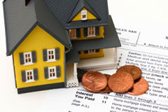 La regulación del desahucio por falta de pago de arrendamiento de vivienda Una casa con unas monedas.