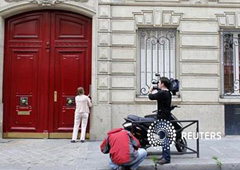 Varios periodistas hacen guardia en la puerta del edificio que alberga las nuevas oficinas del ex presidente francés Nicolas Sarkozy en París, el 3 de julio de 2012