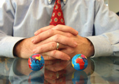 Un abogado sentado con dos bolas del mundo pequeñas
