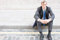 La pesadilla del cliente: el cambio de abogado a última hora Una persona sentada sola en una acera