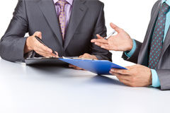 Los despachos de abogados diversifican sus equipos Dos abogados sentados en una mesa
