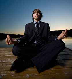 Un chico trajeado en postura de meditación