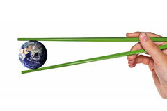 Más allá de nuestras fronteras Bola del mundo cogida con unos palillos verdes