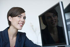 La satisfacción del cliente de Servicios Jurídicos Una mujer reflejando su cara en la pantalla de un ordenador.