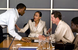 Gestión positiva de conflictos: reflexiones creativas para superar conflictos Dos personas discutiendo a cada lado de la mesa y en medio una persona para intermediar