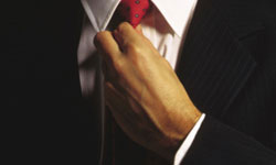 Un hombre anudándose una corbata.