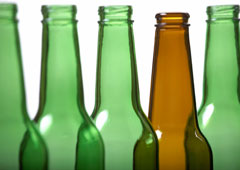 Cuatro botellas verdes y una marrón.