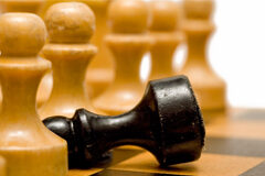 La gestión del despacho como ventaja competitiva En un tablero una ficha negra tumbada frente a las otras que están en pie