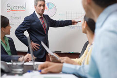 Estrategia, comunicación y liderazgo: claves para conseguir un despacho de éxito Una reunión de trabajo donde en la pizarra se ve la palabra 'Success (éxito)' y dibujan esquemas y gráficos