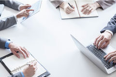 De la gestión de casos a la gestión de proyectos en los despachos de abogados Mesa con personas con portátil y personas con libretas