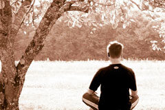Mindfulness Una hombre de espaldas sentado en un campo