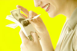 mujer ojeando sonriente un fajo de billetes