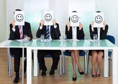 Cuatro personas sentadas con caritas delante de sus caras Cuatro personas sentadas con caritas delante de sus caras